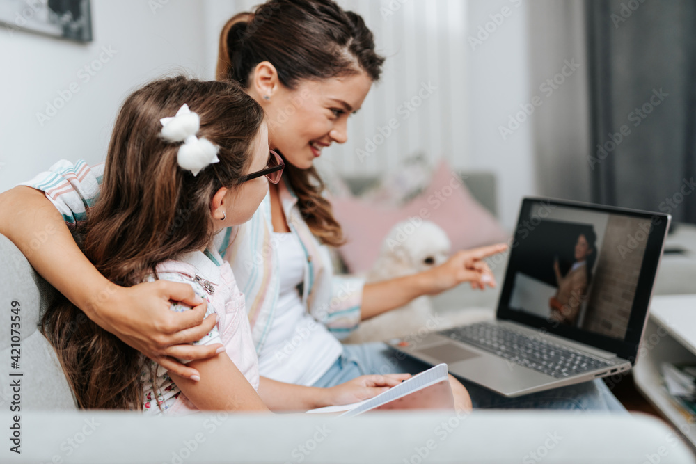 Mother is helping her daughter to follow online classes due to coronavirus. Mother is helping her daughter to follow online classes due to coronavirus.