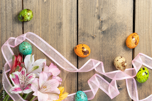 Cuadro en lienzo background from painted eggs and multi-colored flowers on wooden table