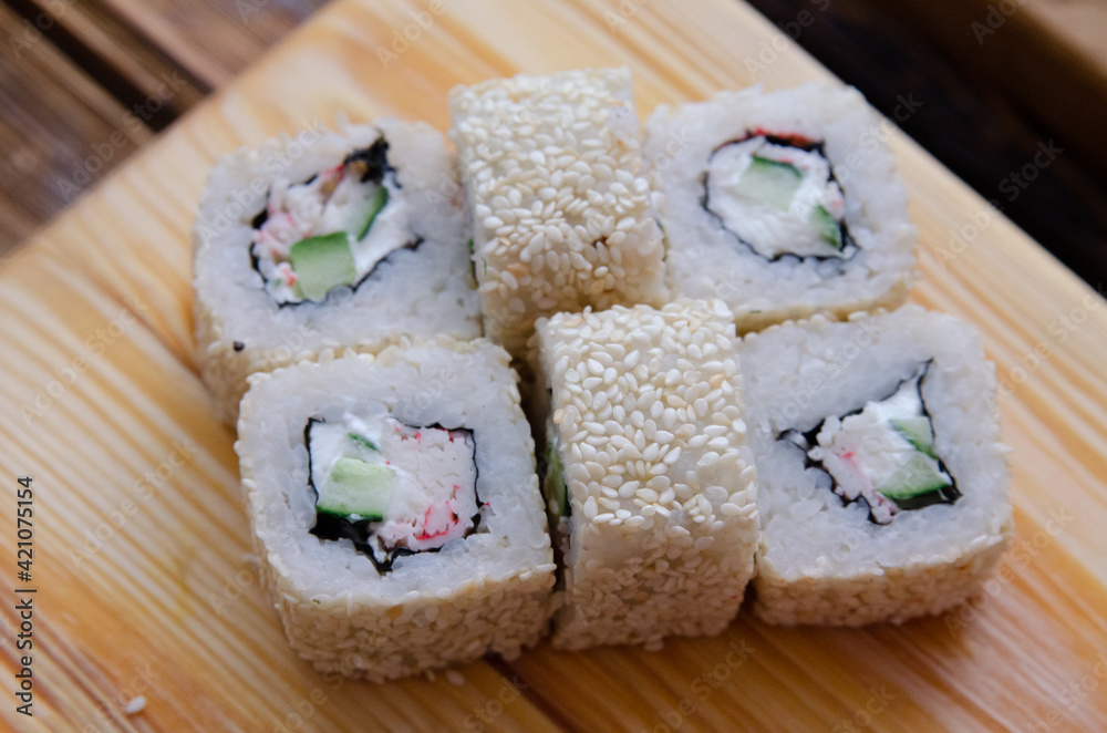 Set of sushi rolls on a wooden board Set of sushi rolls on a wooden board