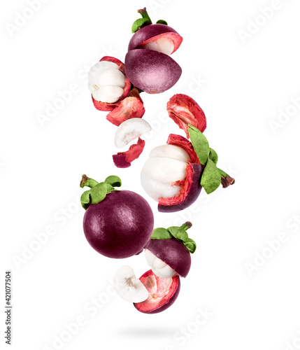 Whole and sliced ripe mangosteen in the air on a white background