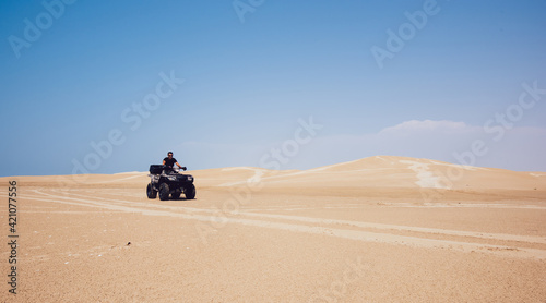 Anonymous man riding ATV in desert