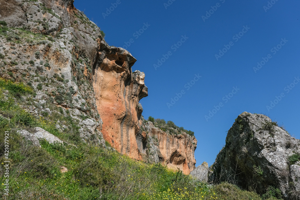 Colorful hard limestone cliffs and caves in Nahal [stream] Aviv deep canyon, east of Upper Galilee, Northern Israel, South of Lebanon border, Israel.