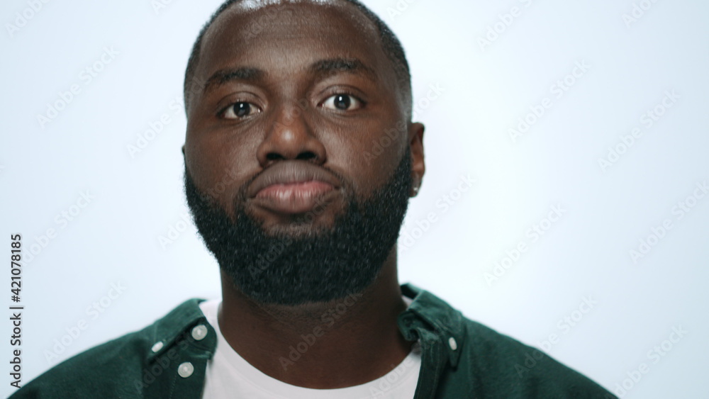 Closeup of excited african american man making funny faces in grey background. Closeup of excited african american man making funny faces in grey background.