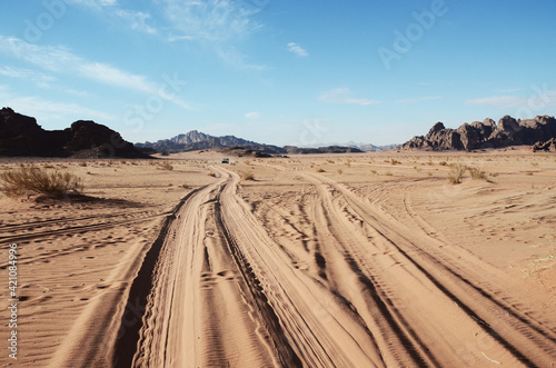 Jordan, Wadi Rum Desert: Scenic landscape view of the desert with mountains and tire tracks on the sand 