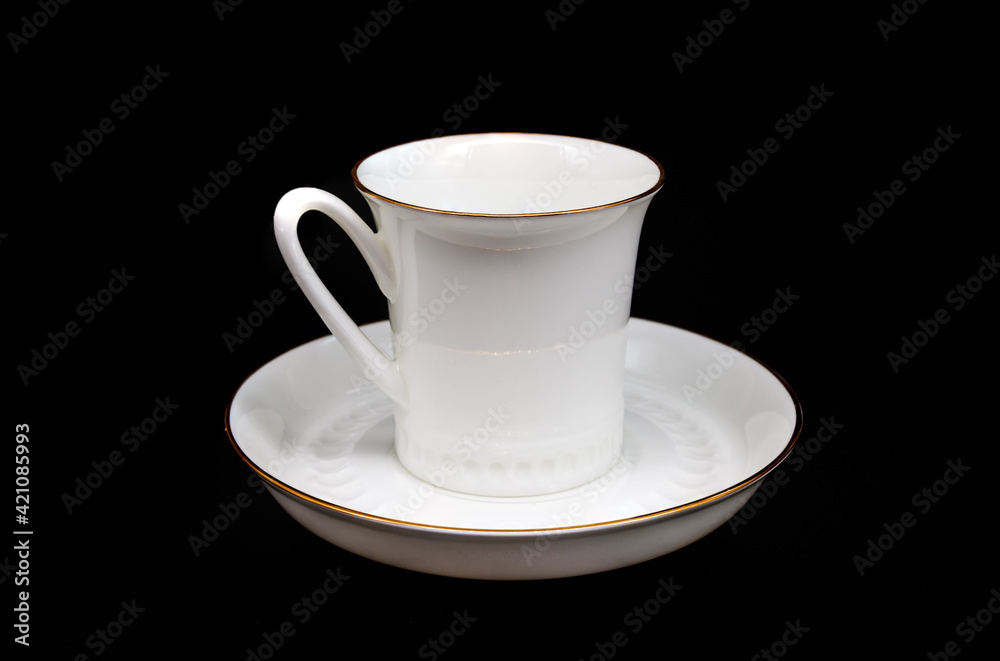 white cup and saucer for coffee on a black background close up white cup and saucer for coffee on a black background close up