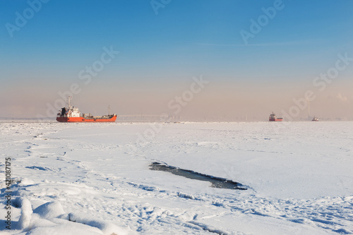 Winter shipping. Big cargo ships in frozen ice sea