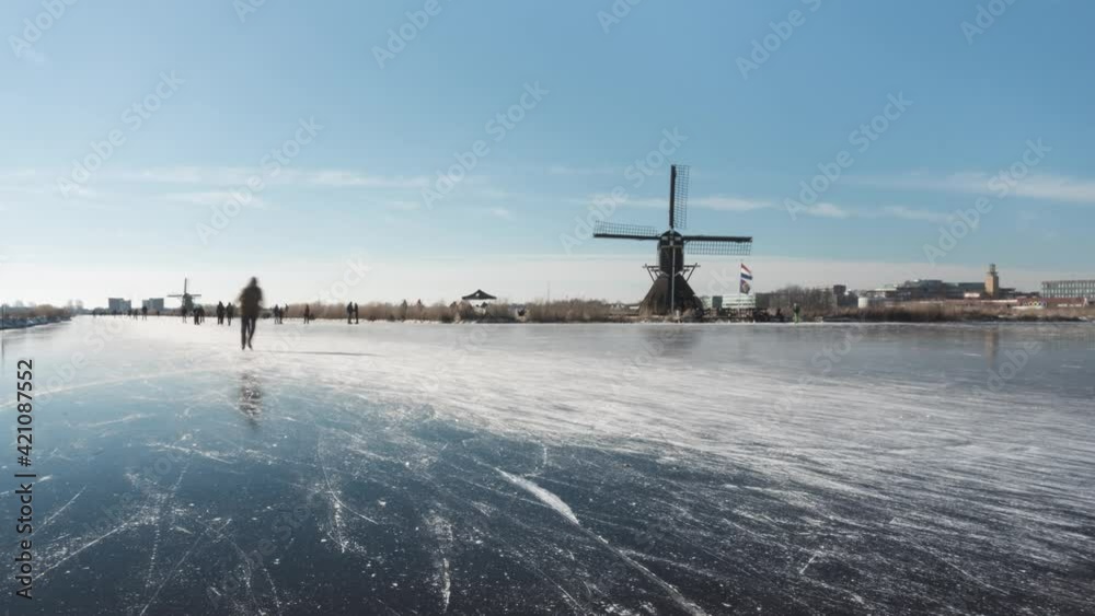 Ice skaters in Netherlands on frozen canal, beautiful winter time lapse