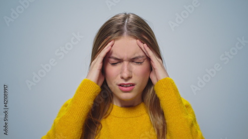 Closeup worried woman touching head with hands at camera on grey background.