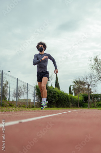 Young man running on the track in the park