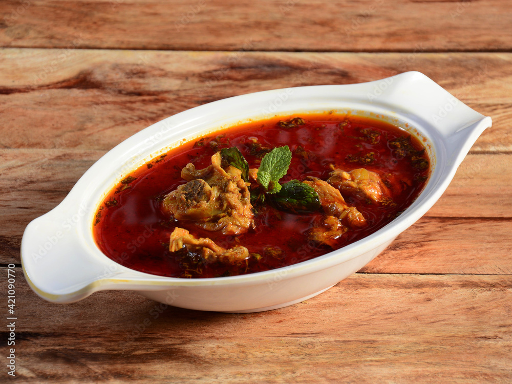 Chicken masala made of indian spices served in a bowl over a wooden rustic background. selective focus Chicken masala made of indian spices served in a bowl over a wooden rustic background. selective focus