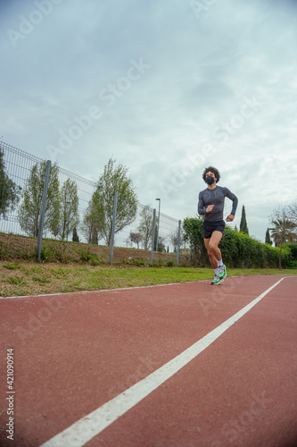 Young man running on the track in the park