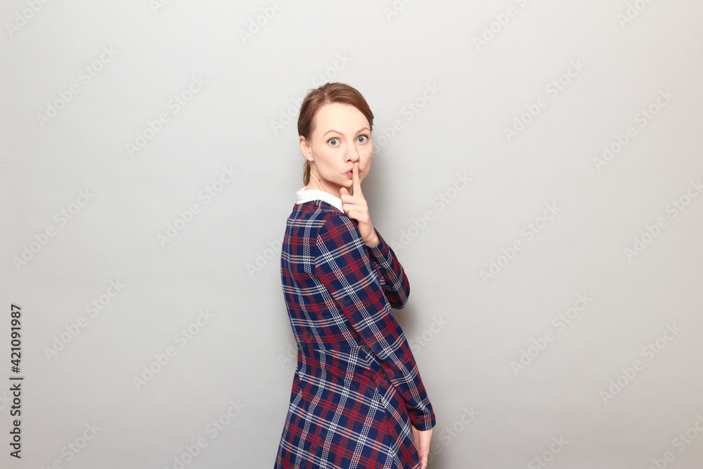 Portrait of strict woman showing silence gesture with finger over lips Portrait of strict woman showing silence gesture with finger over lips