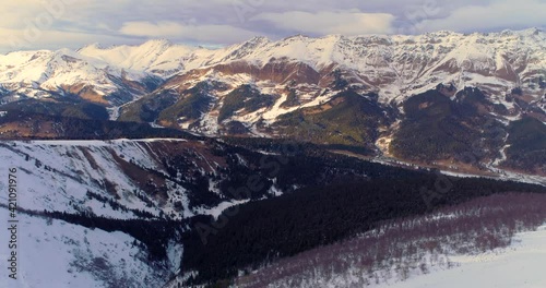 Snowy mountains on blue sky in sunny weather, flight, Caucasus mountains Arkhyz