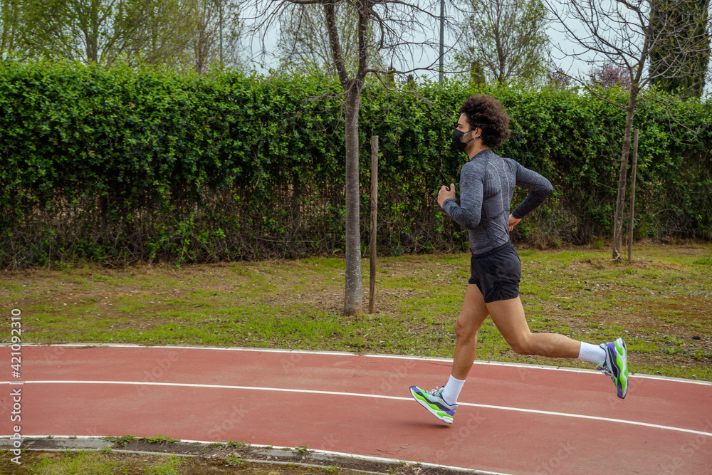 Obraz premium Young man running on the track in the park