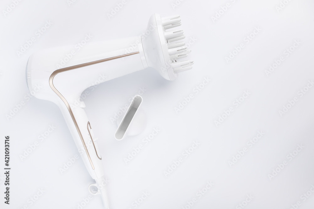 Hairdryer for drying hair with a diffuse and flat nozzle for styling on a white background. Top view. Hairdryer for drying hair with a diffuse and flat nozzle for styling on a white background. Top view.