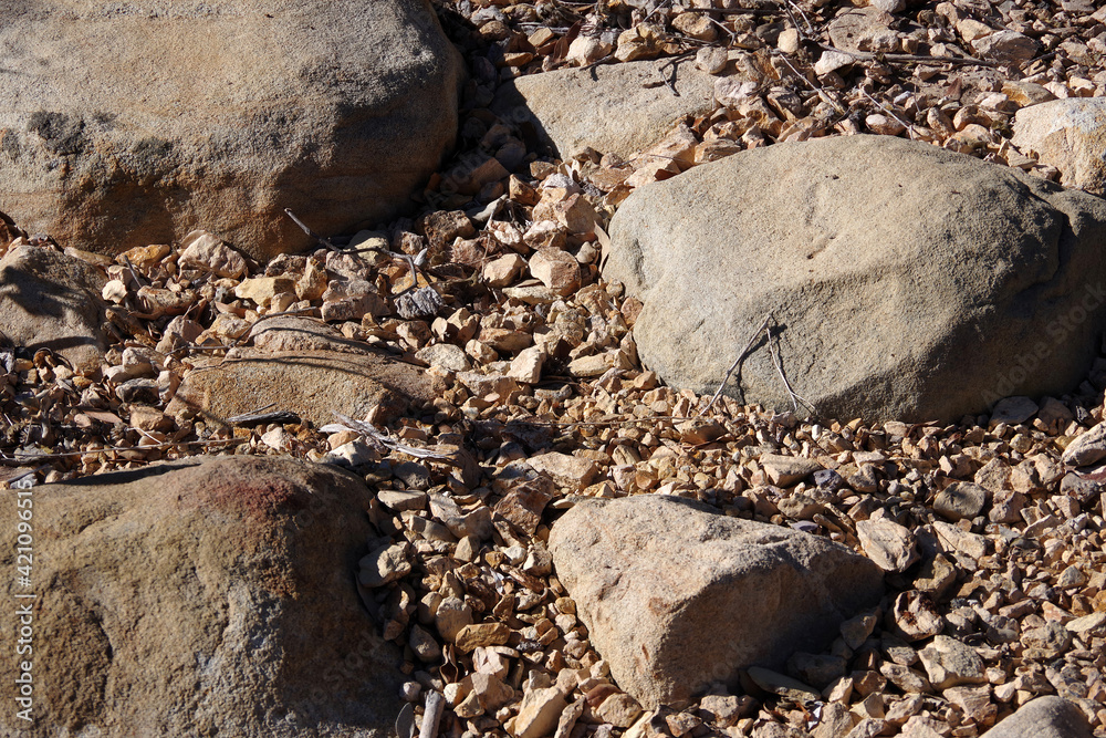 High angle full frame close-up view of a dry desert ground with rocks and stones and gravel High angle full frame close-up view of a dry desert ground with rocks and stones and gravel