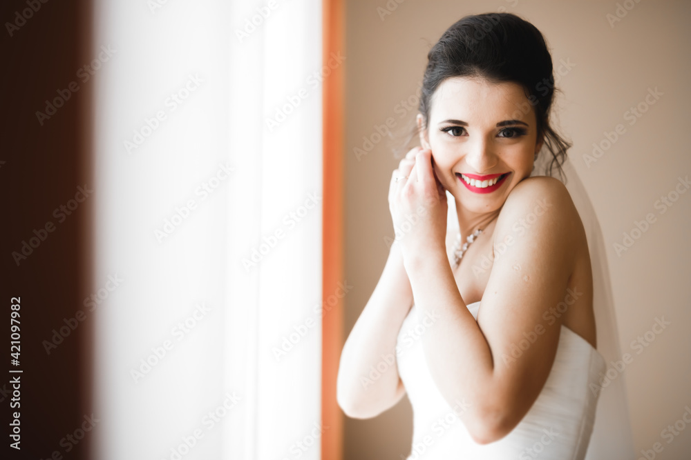 Luxury bride in white dress posing while preparing for the wedding ceremony Luxury bride in white dress posing while preparing for the wedding ceremony