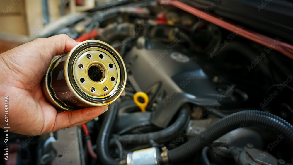 Close up hands of mechanic doing car service and maintenance. Oil and fuel filter changing.Car maintenance concept. Close up hands of mechanic doing car service and maintenance. Oil and fuel filter changing.Car maintenance concept.