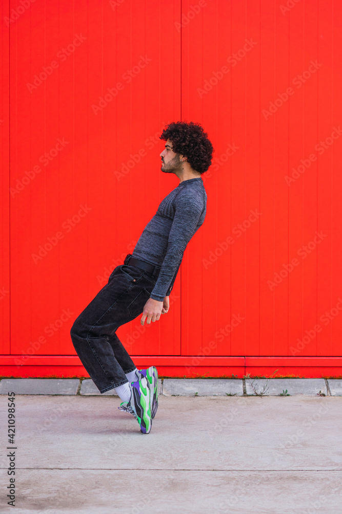 Portrait of a young man dancing in a red wall Portrait of a young man dancing in a red wall