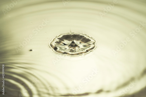 Close up view of drops making circles on water surface isolated on background.