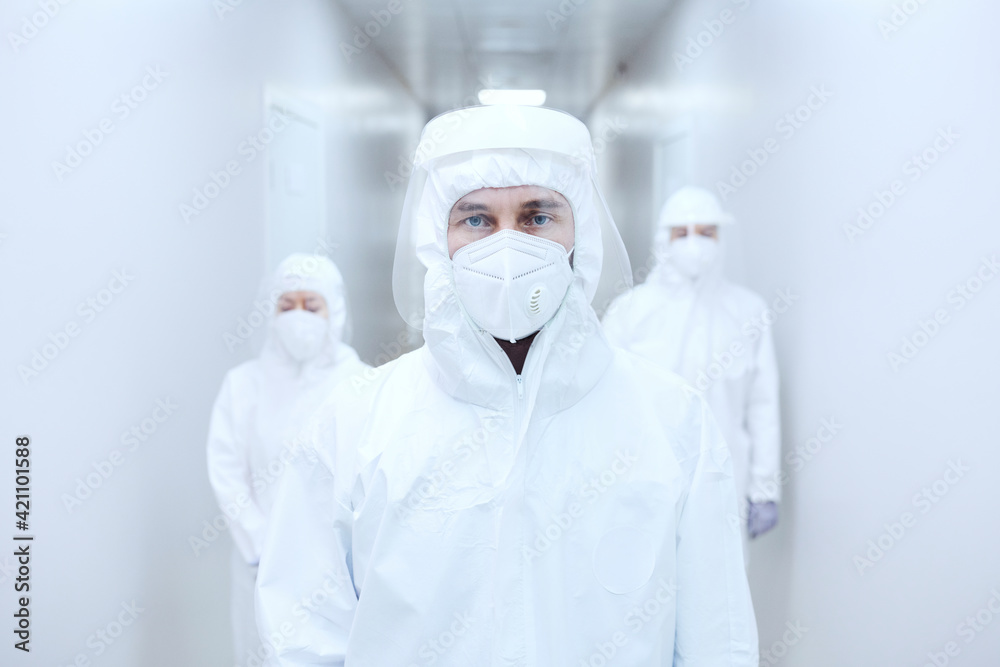 Portrait of doctor in protective wear standing at hospital corridor during pandemic Portrait of doctor in protective wear standing at hospital corridor during pandemic