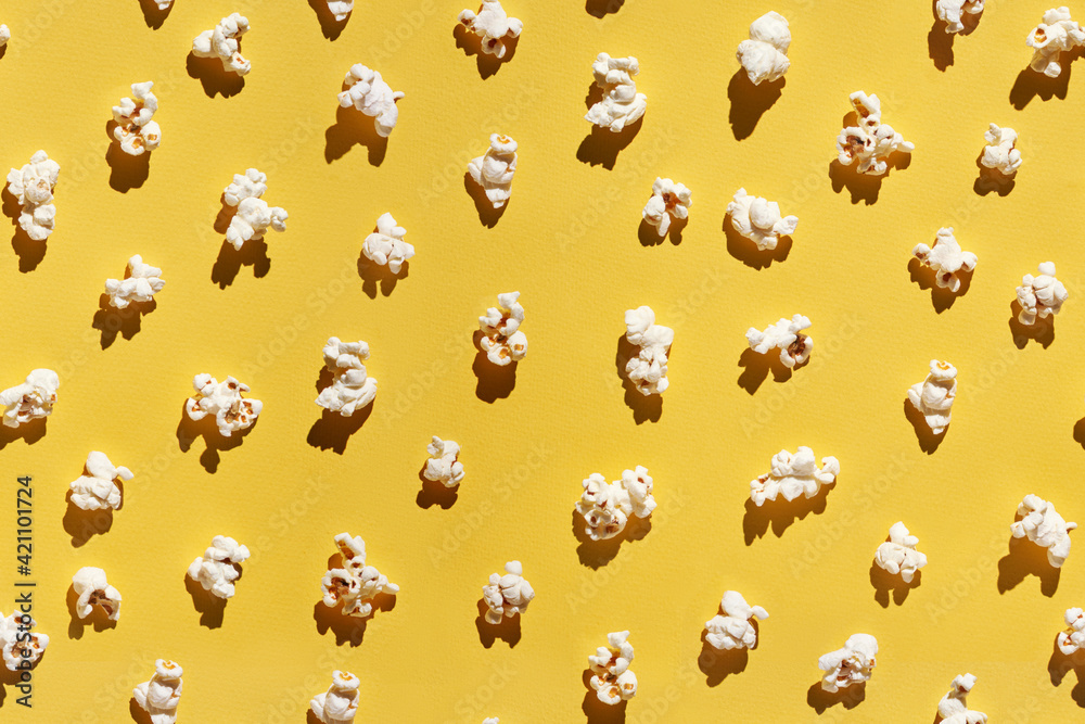 Obraz premium White popcorn design. Creative wallpaper. Yellow bright background. Cinema food concept. Film delicious snack. Many different pieces. Trendy pattern. Top view layout. Flatlay.
