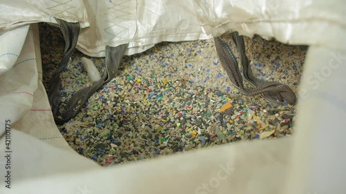 A mixture of plastic and sand to be recycled into something new. New life to old plastic. a worker in a factory recruits a special composition of recycled plastic to create a new product.