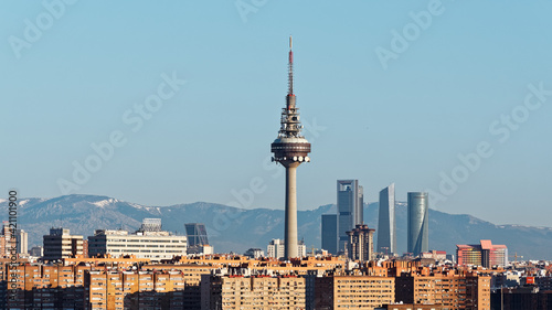 Panoama of the business district in northern part of Madrid city. Snow covered mountains visible in the distance of this image taken just after sunrise.