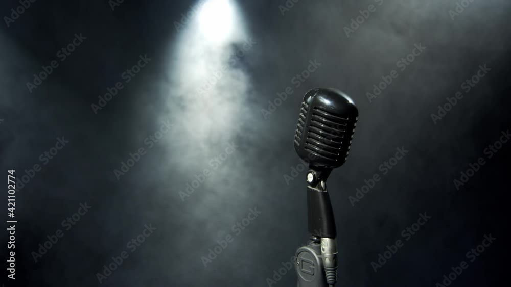 Vintage silver microphone on a stage. Close up shot of grey mic 4K. Dark, night atmosphere