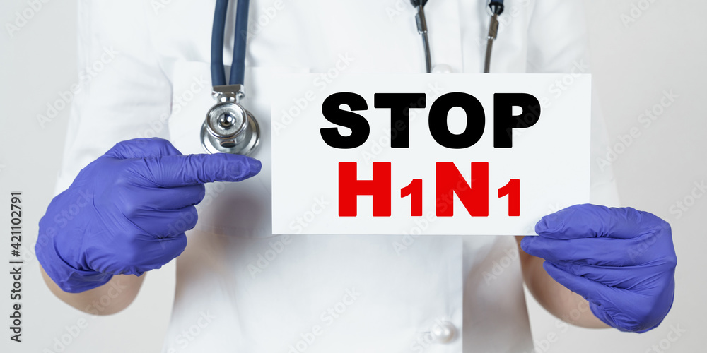 The doctor points his finger at a sign that says - STOP H1N1 The doctor points his finger at a sign that says - STOP H1N1