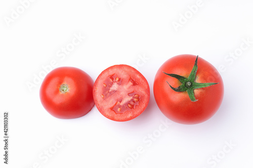 One fresh red tomato, and one tomatoes cut in half top view flat lay isolated on a white background.