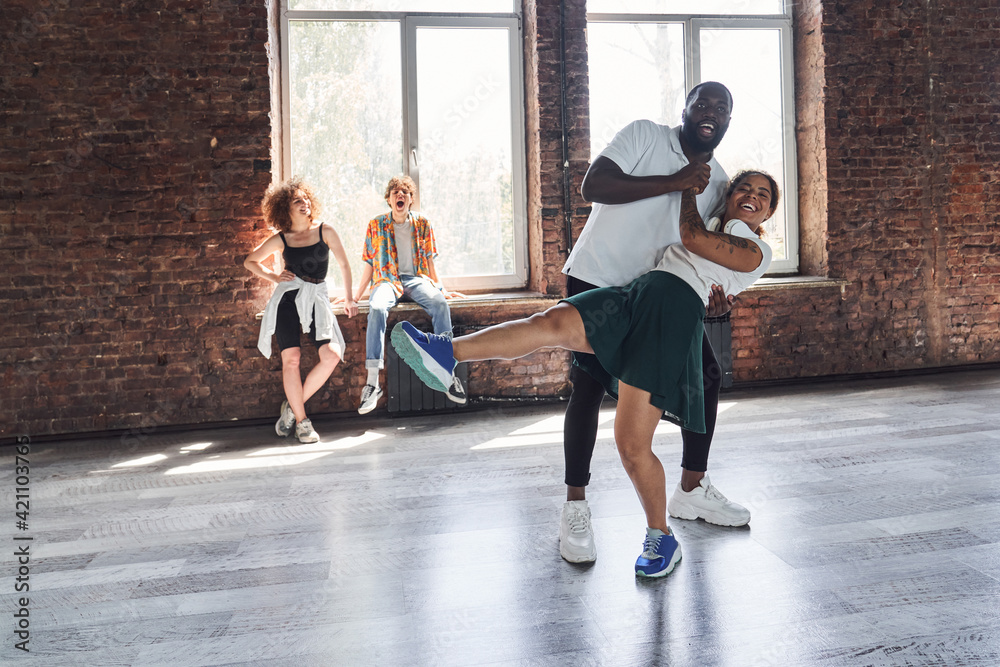 Happy Afro American woman and guy dancing hip-hop style in studio Happy Afro American woman and guy dancing hip-hop style in studio