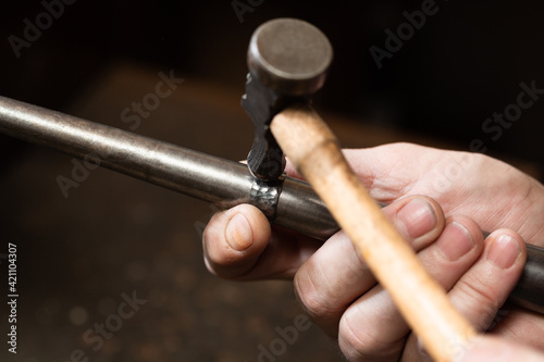 Obraz na plátne foreground, hammer hammering a silver ring to shape it in a jewelry workshop