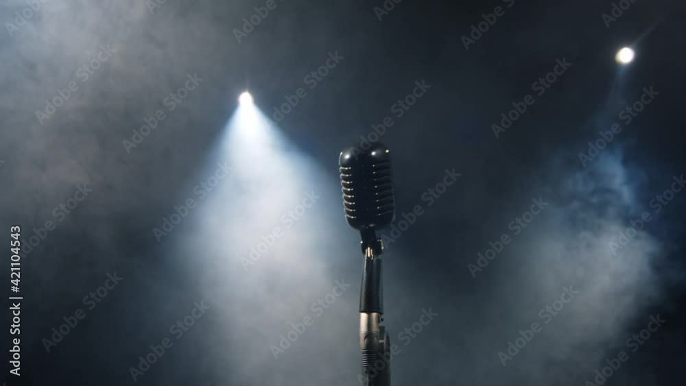 Vintage silver microphone on a stage. Close up shot of grey mic 4K. Dark, night atmosphere