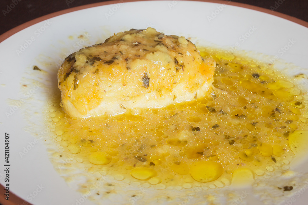 A tasty hake loin in green sauce on a white plate. Fish and healthy food. A tasty hake loin in green sauce on a white plate. Fish and healthy food.