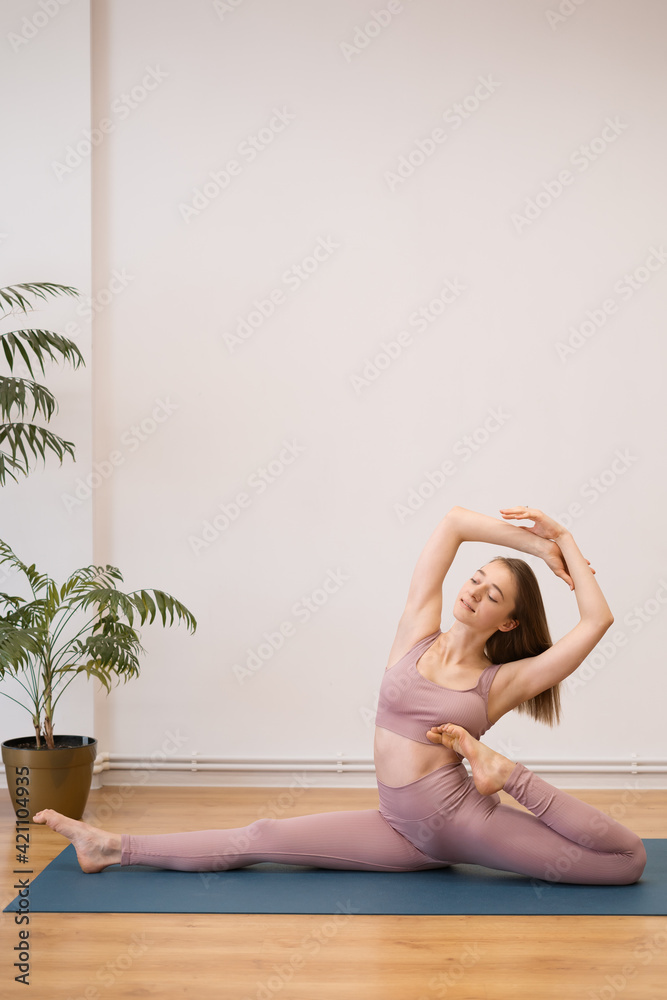 Portrait of beautiful young woman practicing yoga indoor