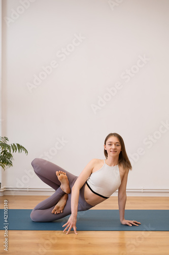 Portrait of beautiful young woman practicing yoga indoor
