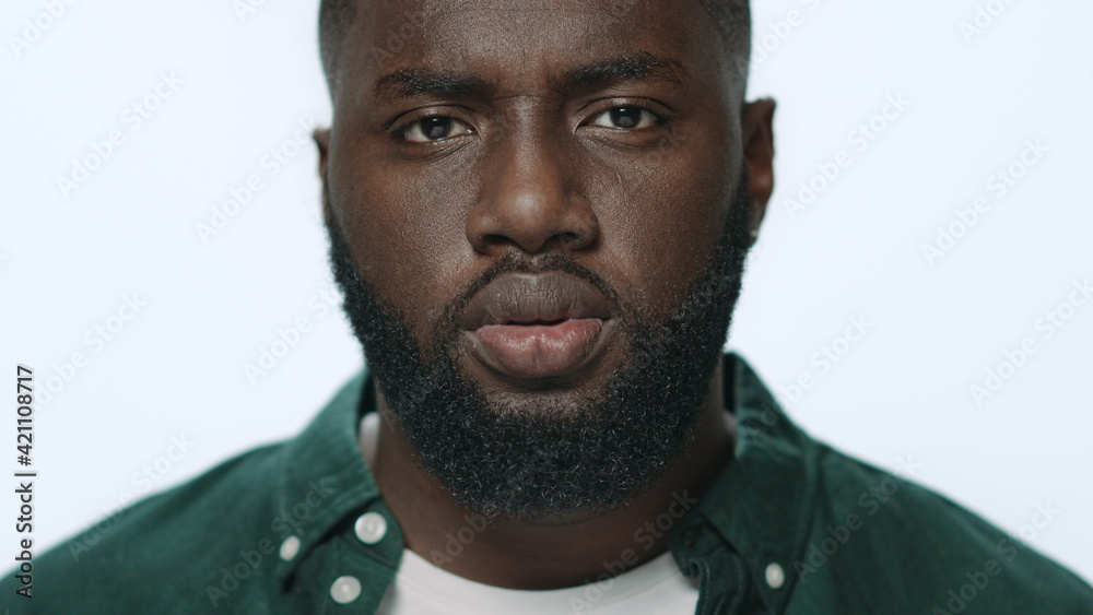 Fototapeta premium Portrait of thoughtful african american guy looking at camera in studio.