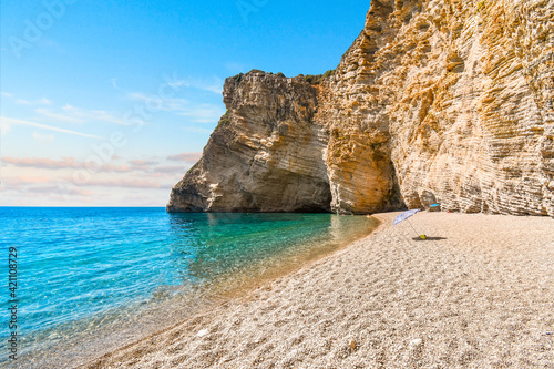 The cliffs and sandy shoreline of Paradise Beach, also known as Chomi Beach in the Aegean Sea off Corfu, Greece.