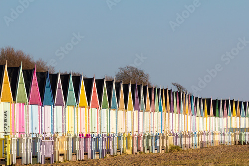 Parade of colourful beach huts on Mersea Island in Essex