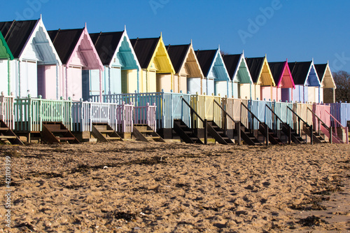 Parade of colourful beach huts on Mersea Island in Essex