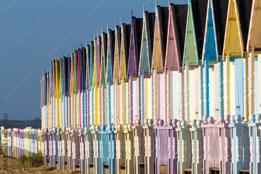 Parade of colourful beach huts on Mersea Island in Essex