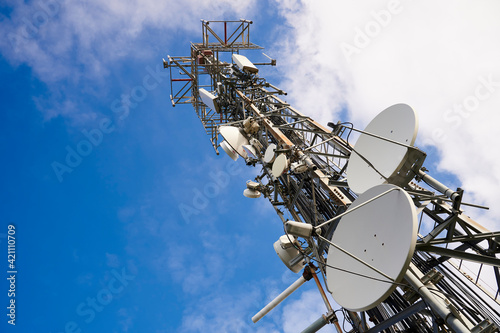 Two towers of communications with antennas against deep blue sky