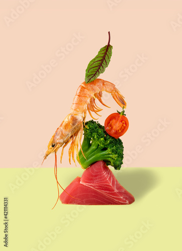 Balansing shrimp, tuna, broccoli and cherry tomatoes on a bright green and pink background. Modern trending food still life photography. Concept Pescataian dien. photo