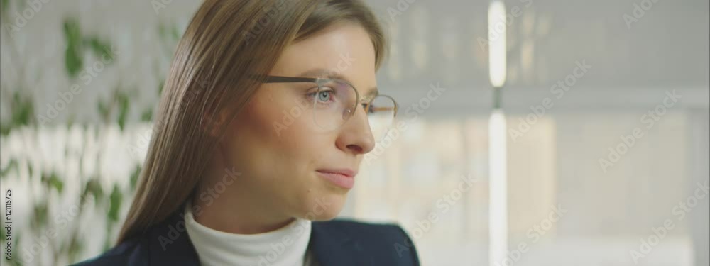 Young casual businesswoman in eyeglasses concentrating on working in front of computer monitor in office. Young casual businesswoman in eyeglasses concentrating on working in front of computer monitor in office.