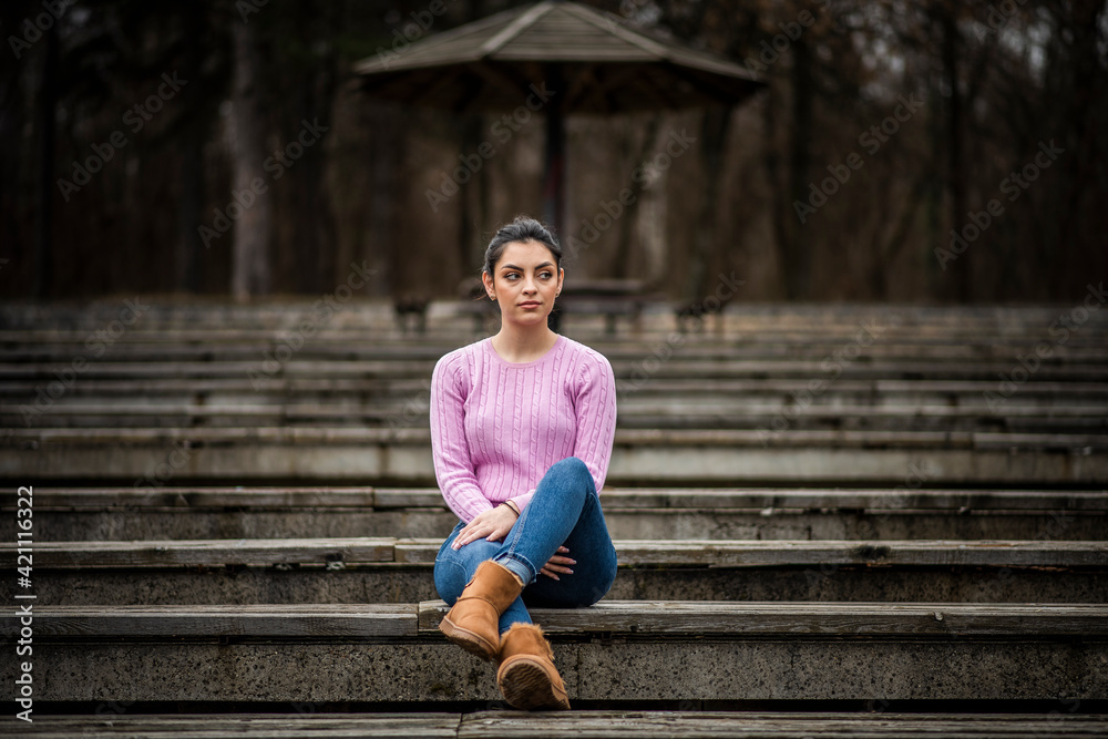 The young girl enjoys posing in autumn colors. The young girl enjoys posing in autumn colors.