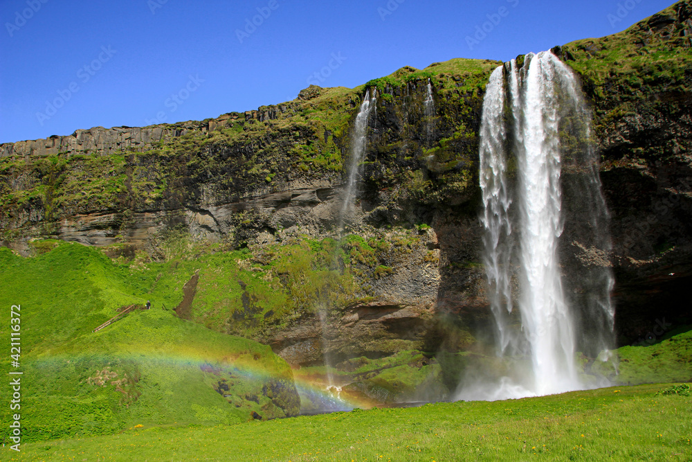 Famous Seljalandsfoss waterfall with small rainbow, Iceland Famous Seljalandsfoss waterfall with small rainbow, Iceland