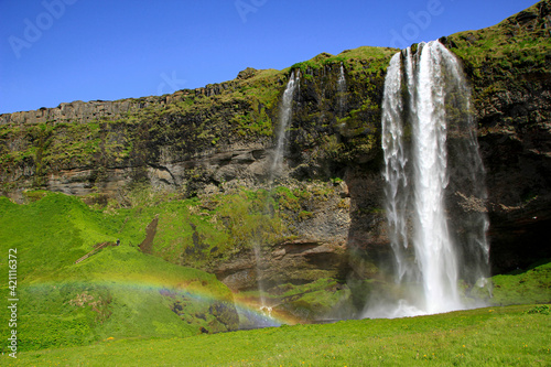 Famous Seljalandsfoss waterfall with small rainbow  Iceland