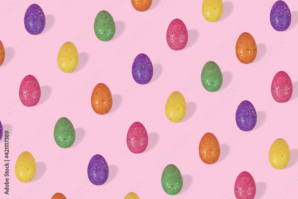 Creative Easter pattern made of colorful eggs arranged on bright blue background.