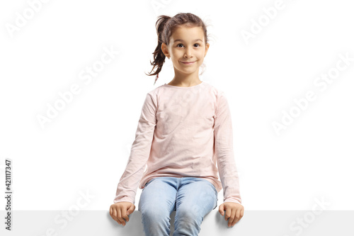 Cute girl sitting on a blank banner